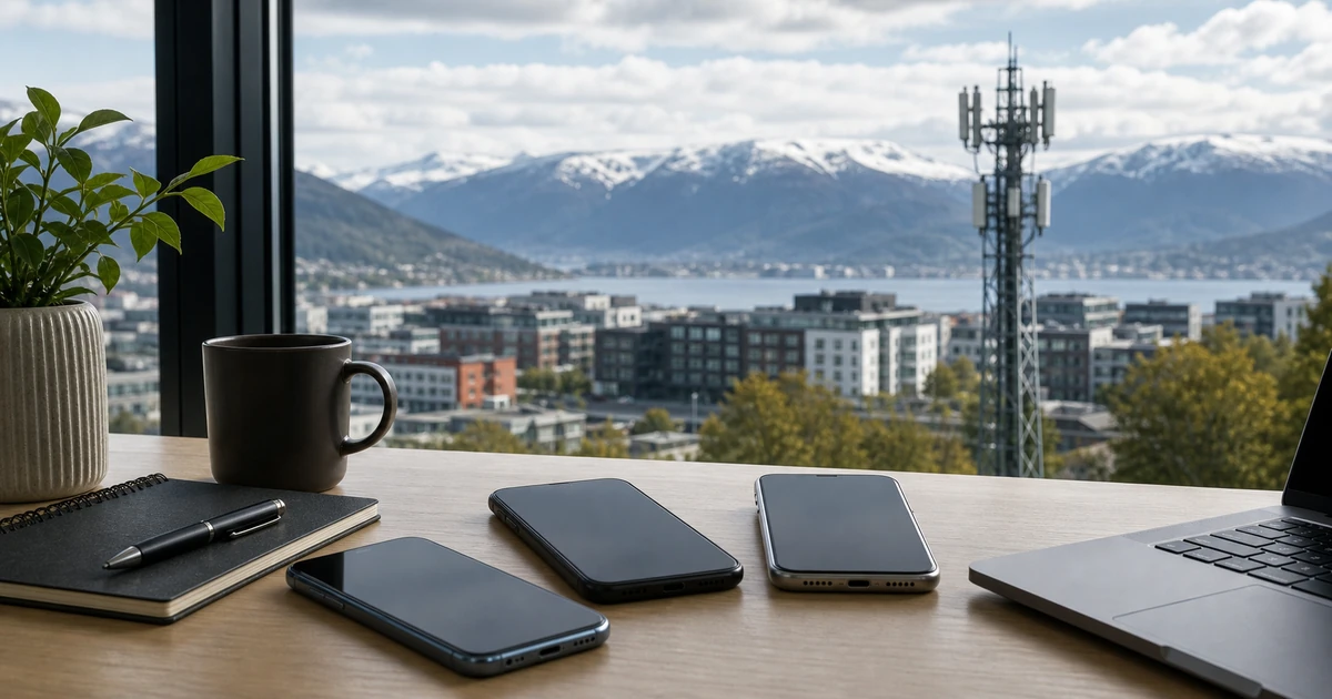 Mobiltelefoner på bord med norsk by, fjell og signalmast i bakgrunnen